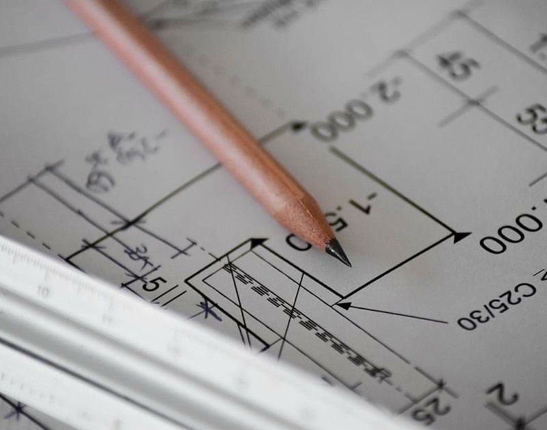 Plan techniczny z naniesionymi odręcznymi notatkami, ołówkiem i fragmentem linijki, sugerujący projektowanie mebli.