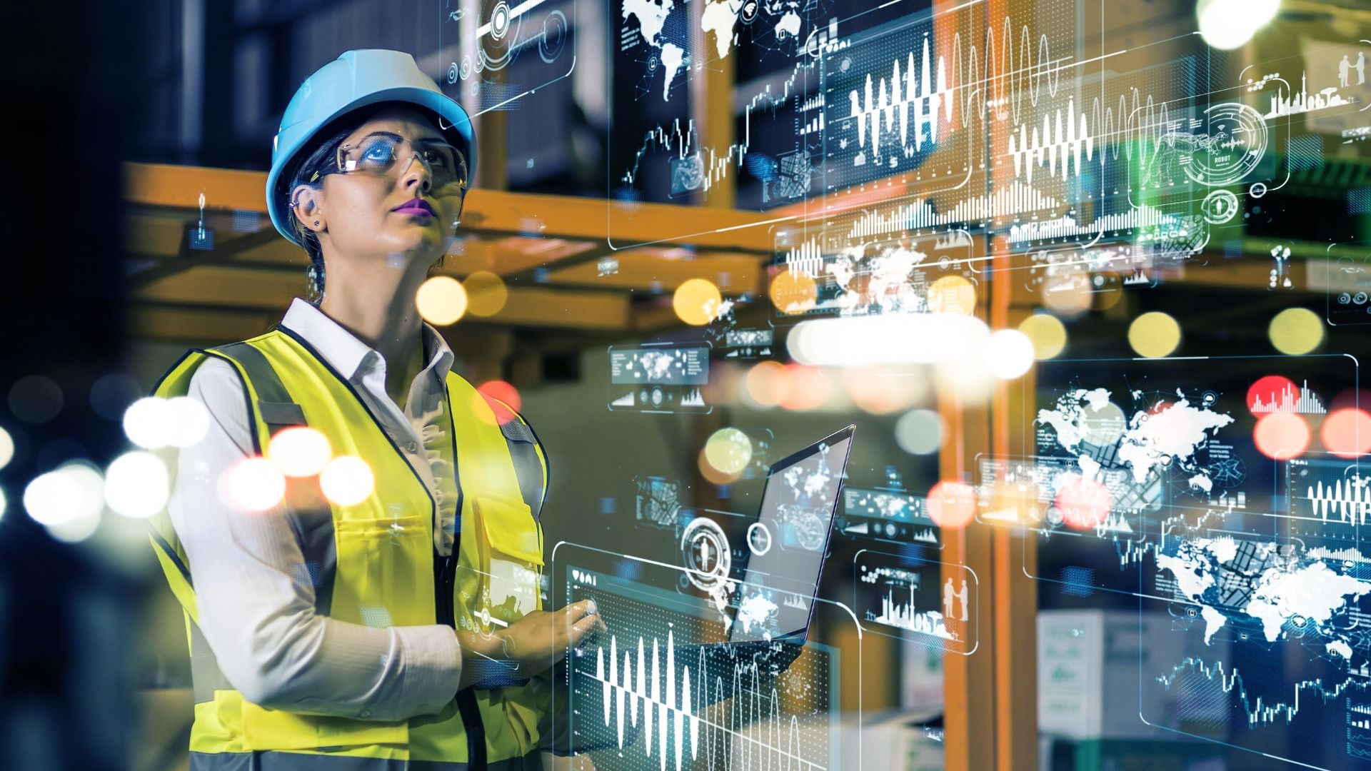 Pracownica w kasku i kamizelce odblaskowej, analizująca dane na laptopie w magazynie, z nałożonymi cyfrowymi wykresami i mapami.