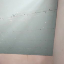 Yuriy Romanenko usługi budowlane - Zamocowana płyta karton gips na suficie, widoczne ślady po wkrętach, przygotowanie do dalszych prac wykończeniowych.