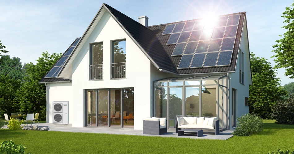 Nowoczesny dom jednorodzinny z panelami słonecznymi na dachu i zewnętrzną jednostką grzewczą, otoczony wypielęgnowanym trawnikiem i zielenią.