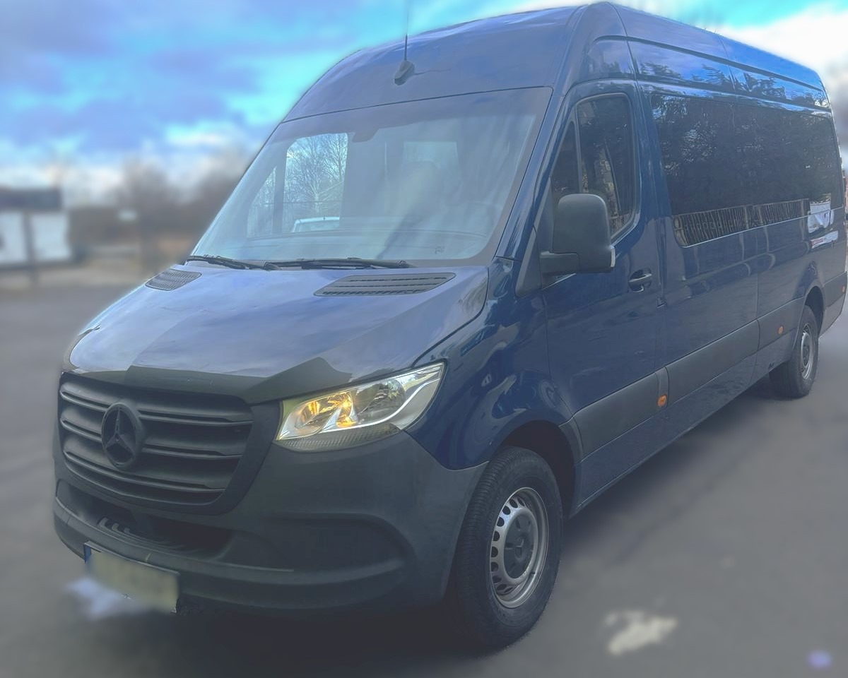 Niebieski bus marki Mercedes-Benz Sprinter z przyciemnianymi szybami, zaparkowany na zewnątrz, widok z przodu pod kątem.