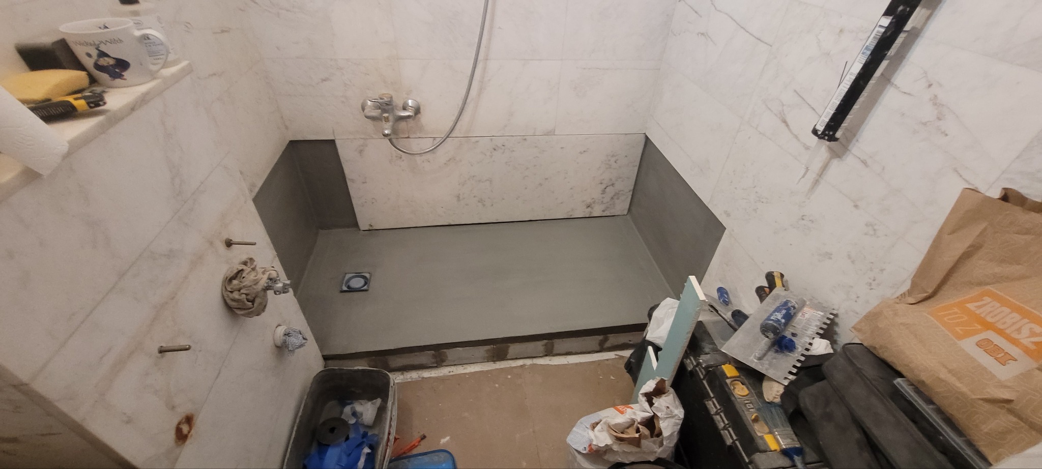 Wykonanie brodzika w istniejącej już łazience z kamieniem na ścianach i podłodze. Kratkę odpływową wybrali właściciele.