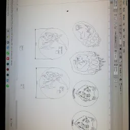 Ekran komputera z otwartym programem CorelDRAW, prezentującym projekt graficzny z motywami zwierzęcymi (wilk, niedźwiedź, ryś) w okręgach z wymiarami, prawdopodobnie przygotowywany do cięcia...