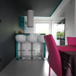 Nowoczesna kuchnia z szarymi ścianami, białymi stołkami barowymi i akcentami w kolorze turkusowym oraz różowym krzesłem przy stole.