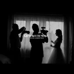 Czarno-białe zdjęcie sylwetek: panna młoda w sukni ślubnej, operator kamery z kamerą i fotograf z aparatem, na tle okna z zasłonami, z widocznym logo 'Oprawa Filmowa Creative Wedding Movie'.