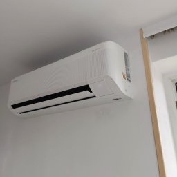 NOVA KLIMATYZACJE - Biały klimatyzator Samsung WindFree zamontowany na ścianie w jasnym pomieszczeniu, widoczny wyświetlacz z temperaturą 17 stopni.