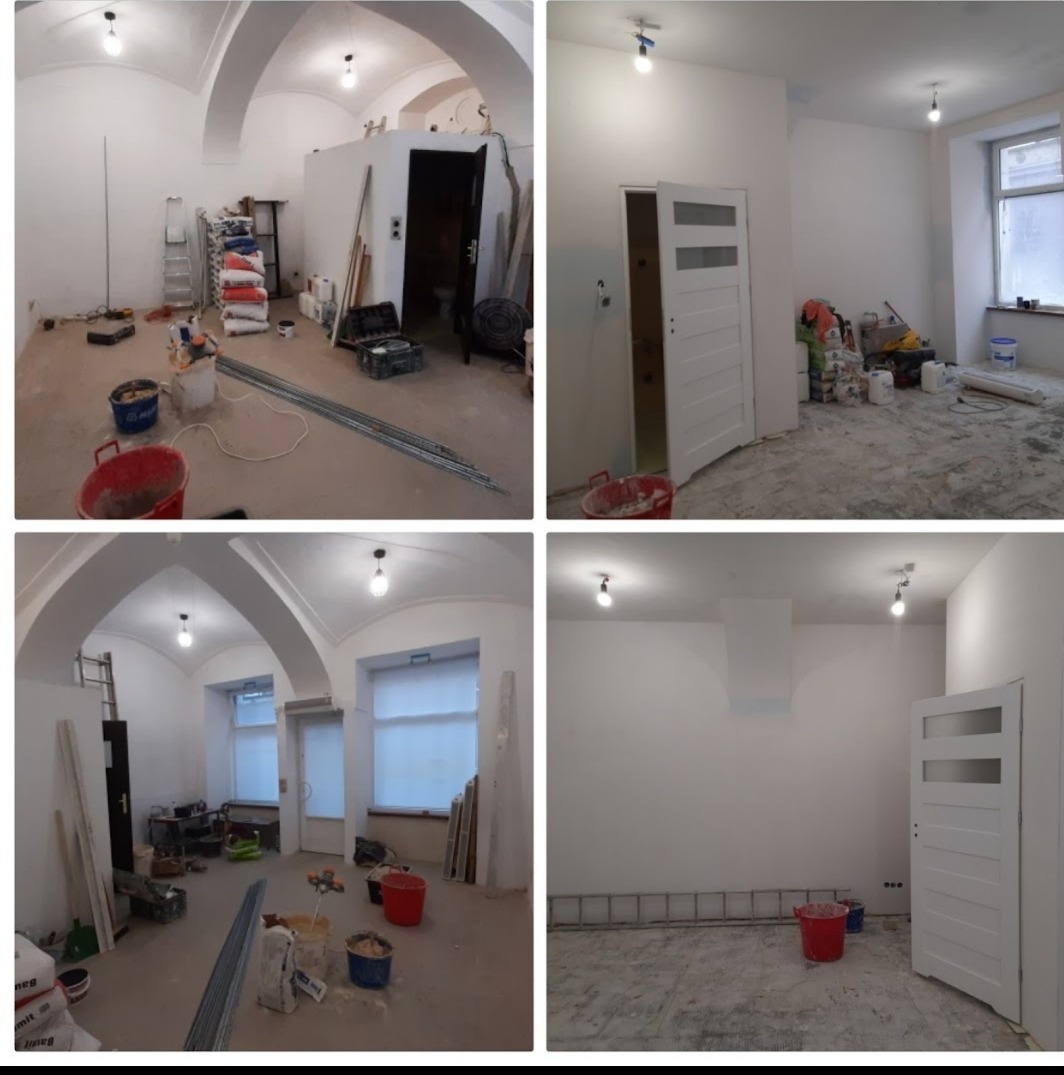 Cztery kadry z remontowanego pomieszczenia z wysokim sklepieniem łukowym, widoczne worki z zaprawą, wiadra, drabiny i otwarte białe drzwi z przeszkleniami, ślady po pracach remontowych na podłodze.