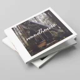 Stos albumów z fotografią leśnej chaty z napisem 'woodhouse' i podpisem 'SCOTTWOODHOUSE'