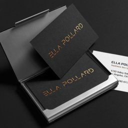 Małe Dobro Mariusz Słoński - Eleganckie wizytówki z czarnego papieru z tłoczonym złotym napisem Ella Pollard, umieszczone w metalowym wizytowniku na ciemnym tle.