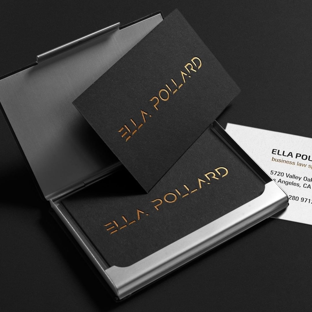Eleganckie wizytówki z czarnego papieru z tłoczonym złotym napisem Ella Pollard, umieszczone w metalowym wizytowniku na ciemnym tle.