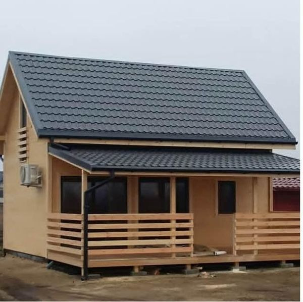 Drewniana altana z grafitowym, metalowym dachem, widoczna z boku. Prosta konstrukcja z poziomymi belkami tworzącymi balustradę. Klimatyzator na ścianie.