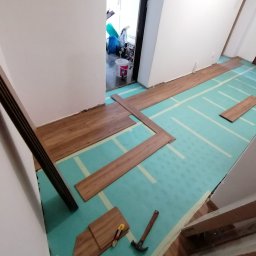 Zdjęcia w czasie układania paneli podłogowych oraz gotowe pomieszczenie po malowaniu i ułożeniu panelii.