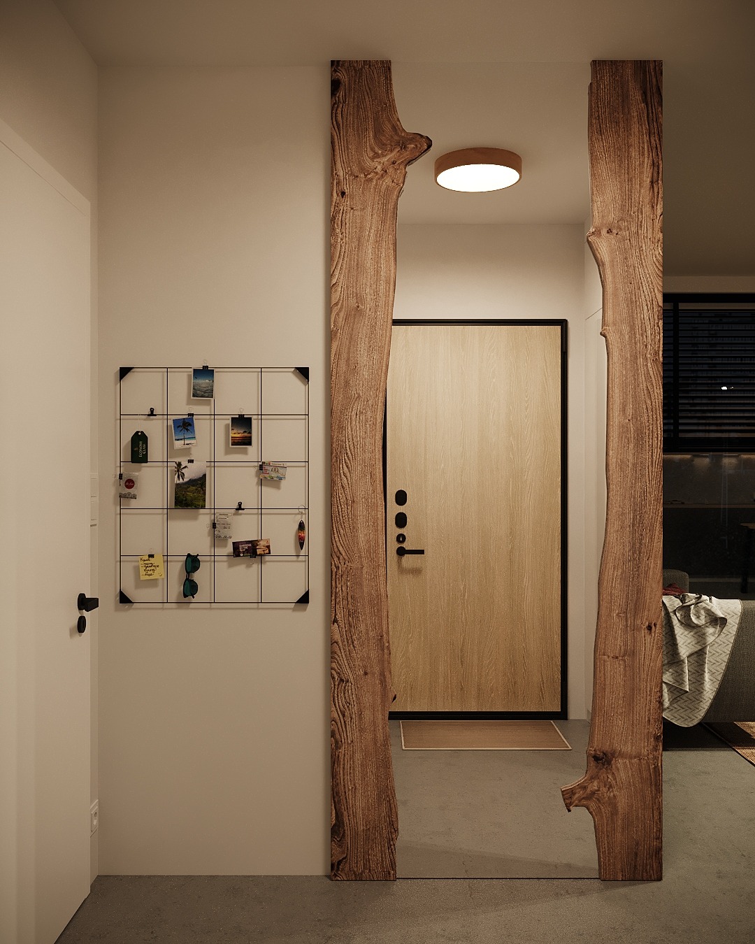 Nowoczesne wejście do mieszkania z drewnianą ramą drzwi z surowego drewna, tablica korkowa z pamiątkami i jasne drzwi wejściowe.