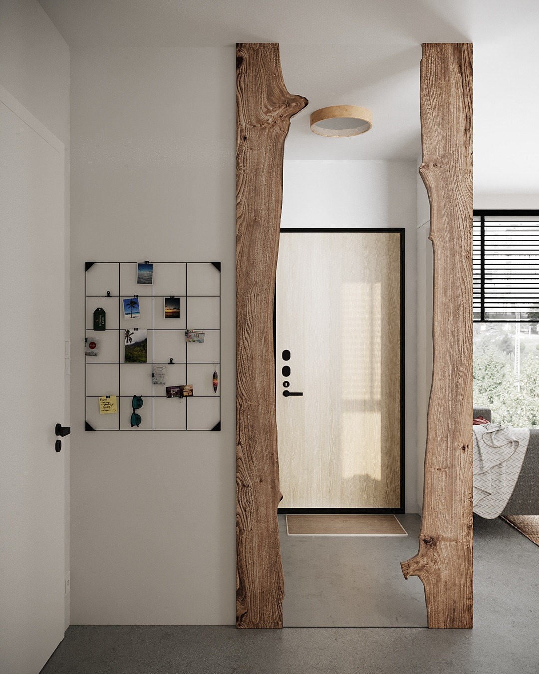 Nowoczesne wejście do mieszkania z drewnianymi elementami dekoracyjnymi przypominającymi fragmenty pnia drzewa, jasne drzwi wejściowe, tablica z pamiątkowymi zdjęciami i okrągła lampa sufitowa.