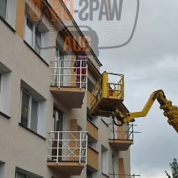 DARO-SPAW AUG DARIUSZ HOŁUBOWICZ - Pracownik na podnośniku koszowym montuje balustrady balkonowe ze stali nierdzewnej w budynku wielorodzinnym.
