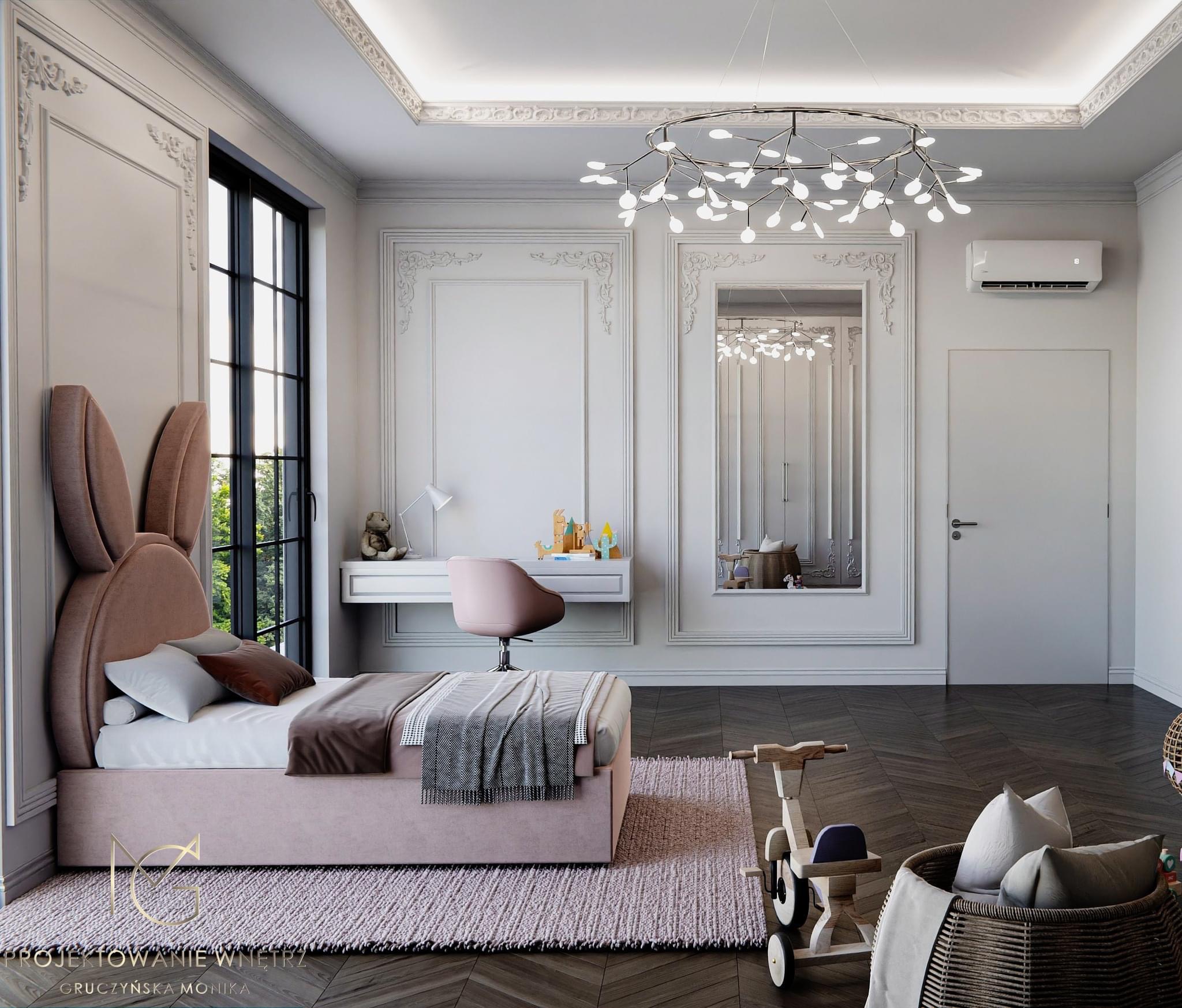 Pokój dziecięcy w stylu klasycznym z łóżkiem z zagłówkiem w kształcie uszu królika, biurkiem z lampką i krzesłem, drewnianą zabawką oraz koszem na zabawki, oświetlony nowoczesnym żyrandolem.