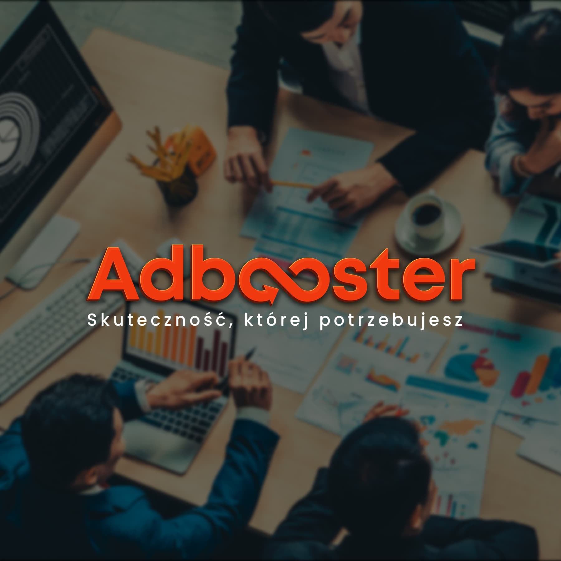 Zespół analizuje dane biznesowe przy biurku z laptopem, dokumentami z wykresami i filiżanką kawy, z widocznym logo Adbooster.