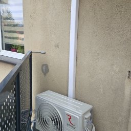 ULTECH Jakub Ulman - Zewnętrzna jednostka klimatyzacji Rotenso Ukura zamontowana na balkonie, widoczna rura odprowadzająca skropliny i narzędzia malarskie w kuwecie.