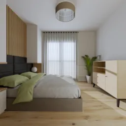 Jasna sypialnia z drewnianą podłogą, łóżkiem z czarnym zagłówkiem z paneli, zielonymi poduszkami i narzutą w odcieniach szarości, drewnianą komodą i lampą sufitową z abażurem.