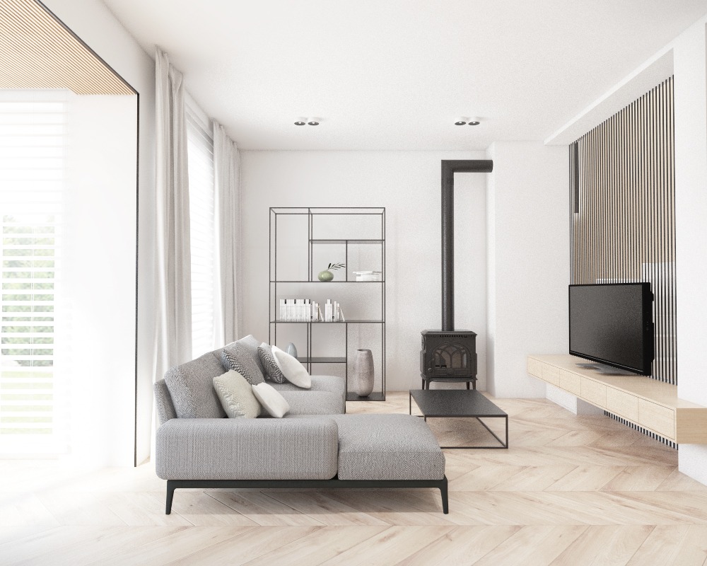 Jasne, minimalistyczne wnętrze salonu z parkietem w jodełkę, szarą sofą modułową, czarnym regałem i piecem wolnostojącym. Ściana z telewizorem wykończona pionowymi lamelami.