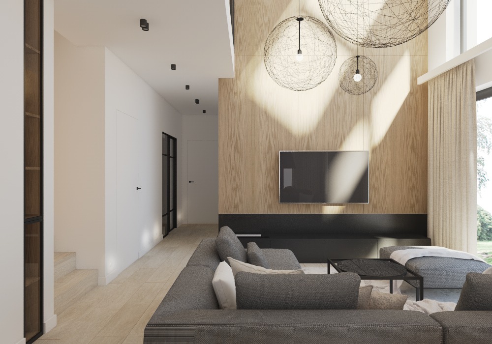 Jasne wnętrze salonu z drewnianą ścianą, wiszącymi lampami kulistymi i szarą sofą modułową.
