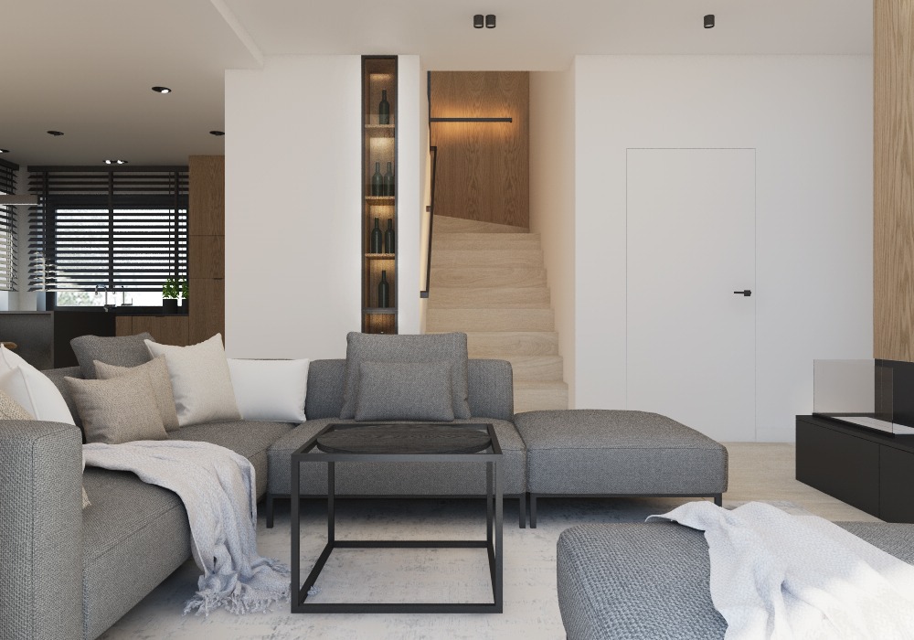 Nowoczesny salon z szarym narożnikiem, czarnym stolikiem kawowym i drewnianymi schodami w tle, oświetlonymi listwą LED, z wbudowaną witryną na wino po lewej stronie.