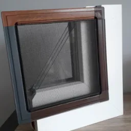 Przekrój ramy okiennej z siatką przeciw owadom, widoczne różne kolory profili: szary, brązowy i biały.