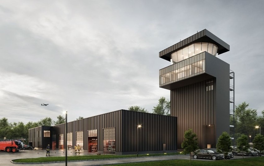 Wizualizacja nowoczesnej remizy strażackiej z wieżą obserwacyjną, widoczne wozy strażackie i strażacy na zewnątrz, samolot na niebie.