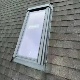 Okno dachowe marki Fakro zamontowane w pokryciu z gontu bitumicznego, widok z góry.