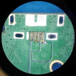 Trzy zbliżenia mikroskopowe na płytę główną urządzenia elektronicznego z widocznym portem USB-C, ukazujące detale połączeń lutowanych i ścieżek obwodu.