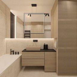 OM Dekor Sylwia Kaczmarek-Bartoszek - Nowoczesna łazienka w beżach: minimalistyczna umywalka, lustro z oświetleniem, drewniane lamele na ścianie, czarna armatura i akcesoria. Spokojna kolorystyka.