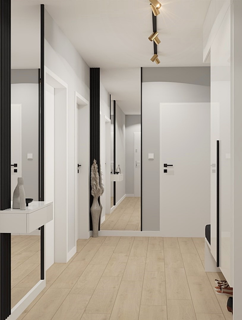 Nowoczesny przedpokój z lustrami, drewnianą podłogą i minimalistycznym oświetleniem punktowym. Wazon z dekoracyjną trawą. Białe ściany i drzwi.