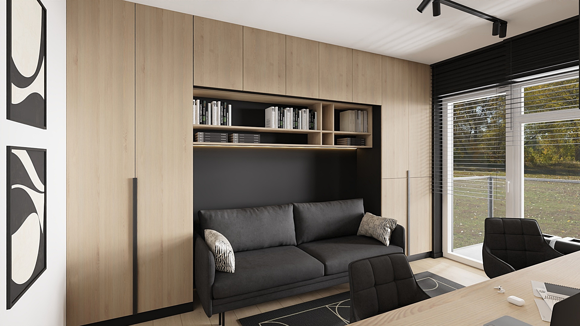 Nowoczesny pokój z sofą w zabudowie, półkami na książki i minimalistycznymi grafikami na ścianie. Jasne drewno szaf i biurka, czarne akcenty. Widok z okna na zieleń.