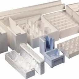 Różnorodne kształtki styropianowe w odcieniach bieli i błękitu, ułożone na jasnym tle, prezentujące ich zróżnicowane formy i zastosowania, od opakowań po elementy konstrukcyjne.