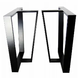 Dwie metalowe nogi do stołu, jedna z elementem chromowanym, o trapezoidalnym kształcie, spawane, widoczne otwory montażowe, na białym tle.