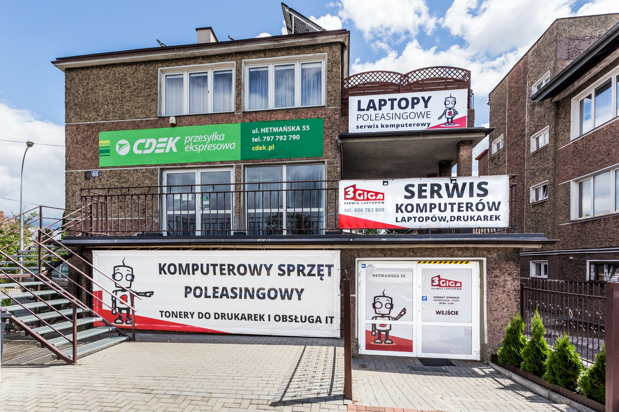Fasada budynku z szyldami firm oferujących sprzęt komputerowy, leasing, naprawy i obsługę IT, widoczne logo 3 Giga i CDEK.