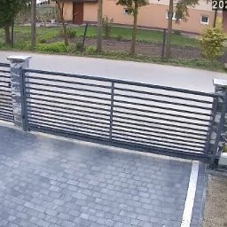 Wieliczka - Automatyczna brama przesuwna z poziomymi profilami, zamontowana na posesji z kostką brukową, widok z kamery IP, data i godzina na zdjęciu.