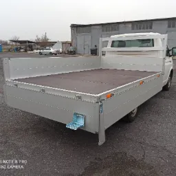 Nowa aluminiowa zabudowa skrzyniowa na samochodzie dostawczym, z rozkładanym stopniem ułatwiającym dostęp do przestrzeni ładunkowej.