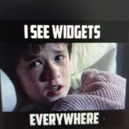 Przerażony chłopiec w łóżku, z tekstem 'I SEE WIDGETS EVERYWHERE' u góry i u dołu kadru.