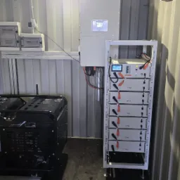 Wnętrze kontenera z agregatem prądotw&oacute;rczym, rozdzielnicami i bateriami magazynu energii Deye. Instalacja w metalowym kontenerze.