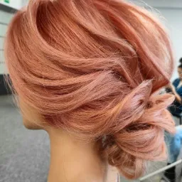 Upiecie z różowych włosów z delikatnymi refleksami, widok z boku, na manekinie.