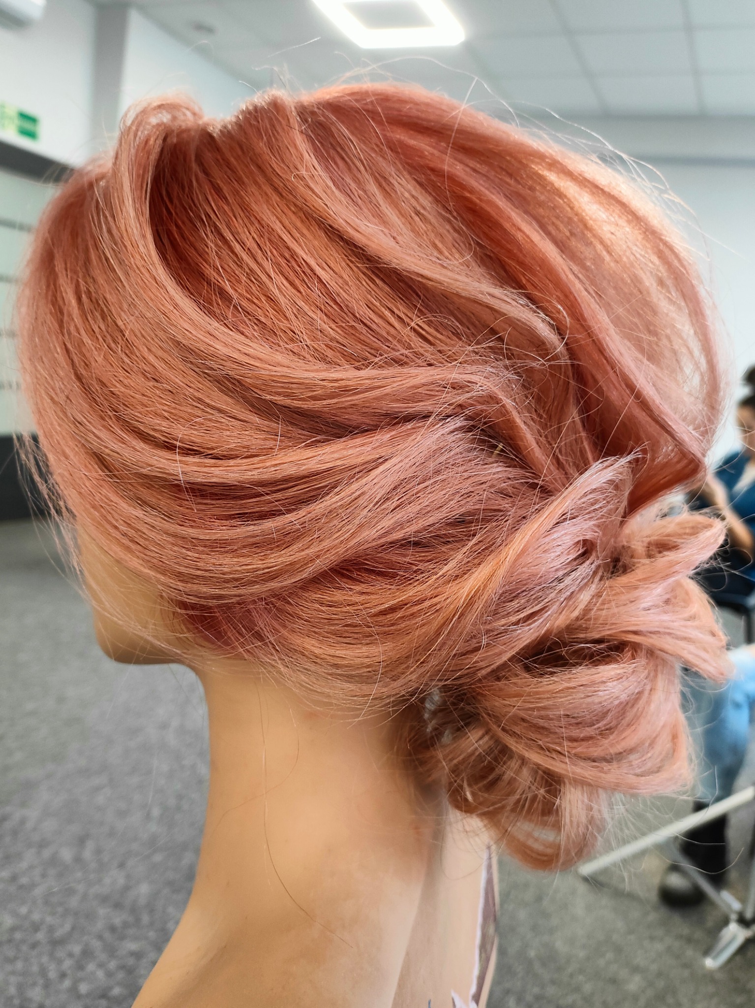 Upiecie z różowych włosów z delikatnymi refleksami, widok z boku, na manekinie.