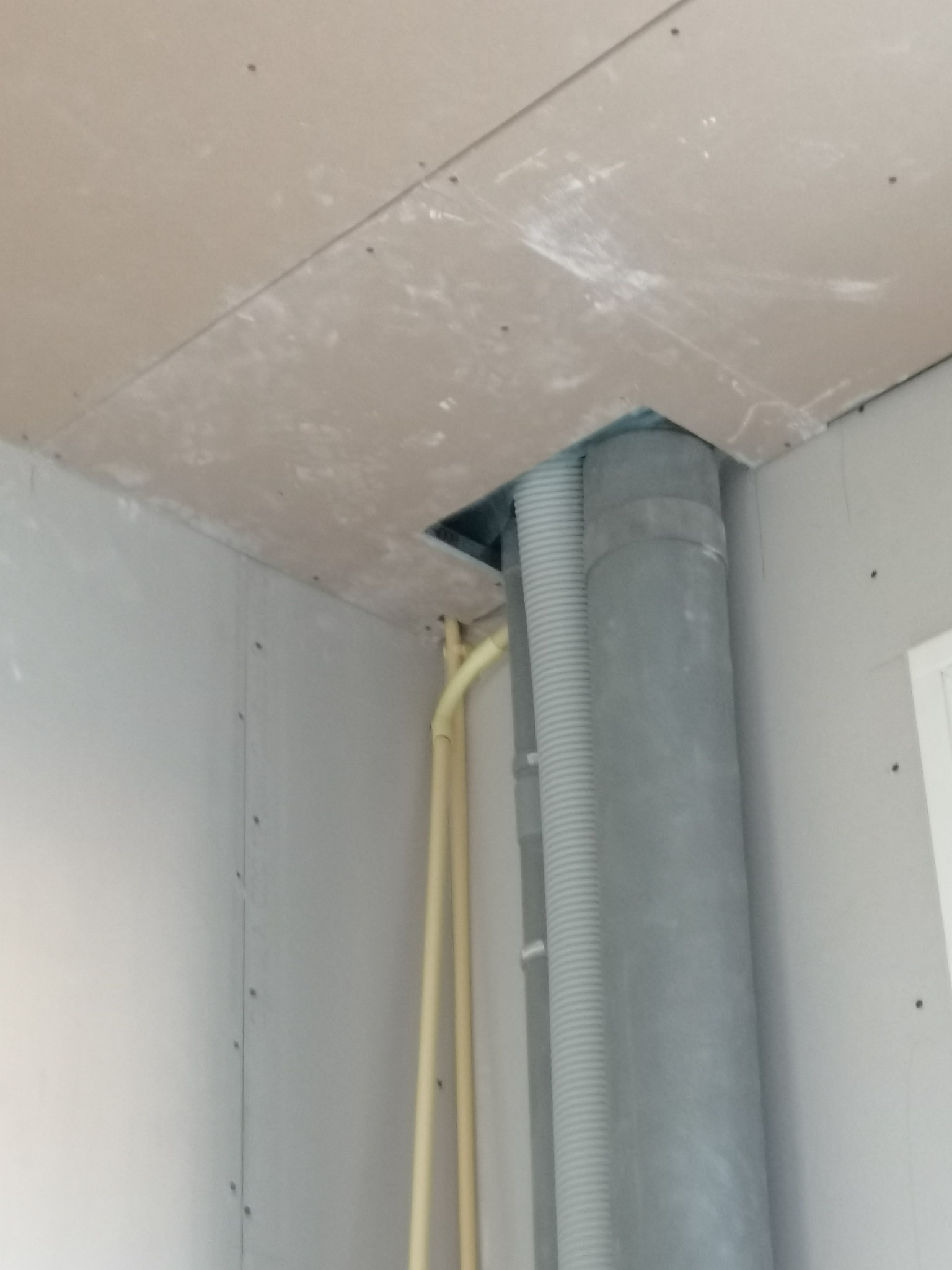 Surowy montaż płyty karton gips w Kole z widocznymi przewodami wentylacyjnymi i rurami instalacyjnymi przed ostatecznym wykończeniem.