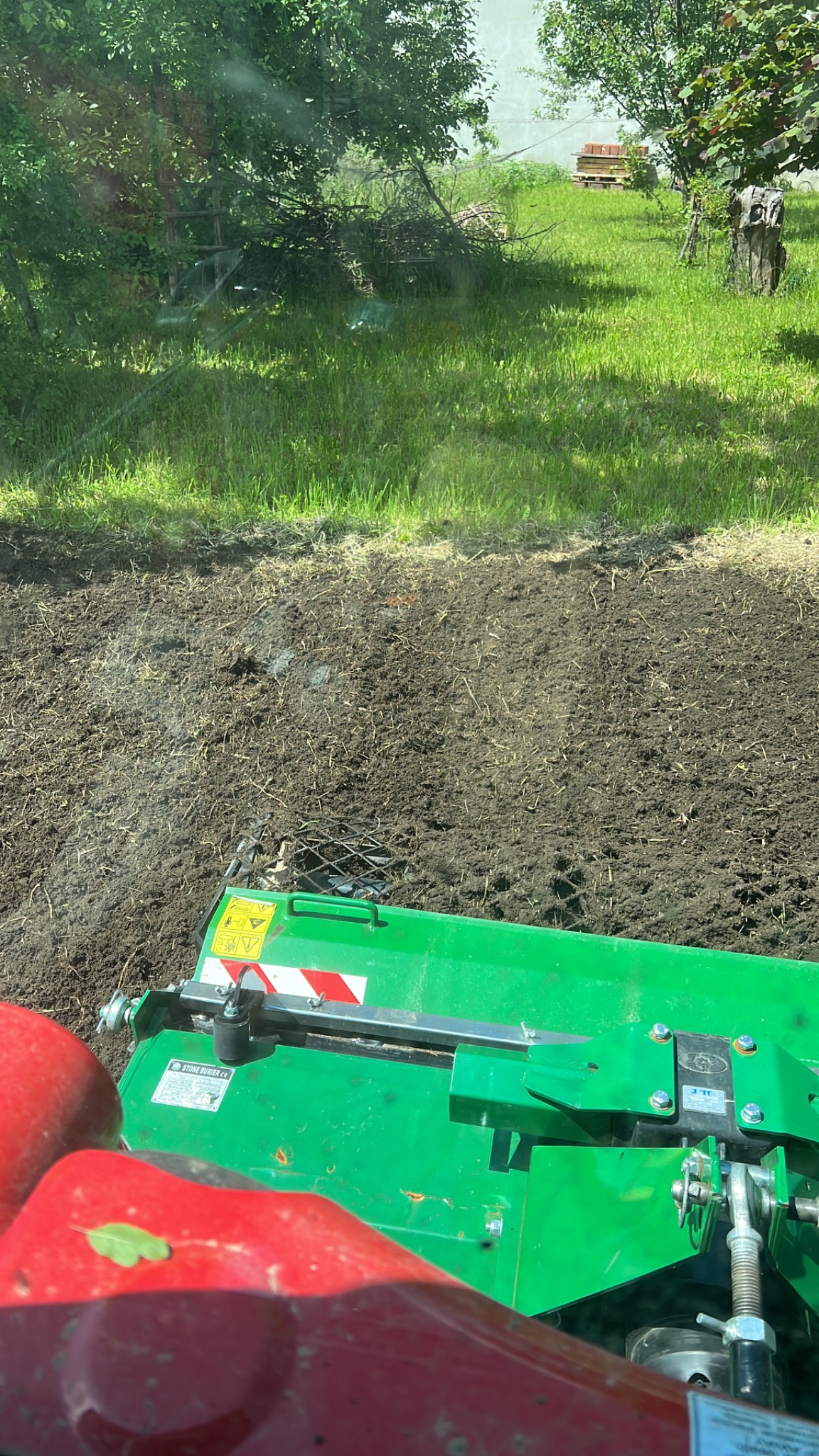 Glebogryzarka separacyjna w trakcie pracy na polu, widok z perspektywy operatora, obrobiona ziemia i trawa w tle.