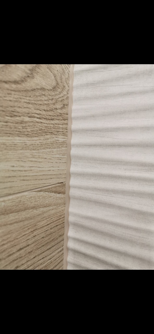 Połączenie płytek: imitacja drewna i biała, falista struktura. Widoczna fuga w odcieniu beżu.