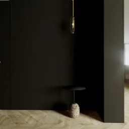 Minimalistyczne wnętrze: czarne drzwi z złotą klamką, marmurowy stolik, wisząca lampa i widok na kuchnię z roślinami.