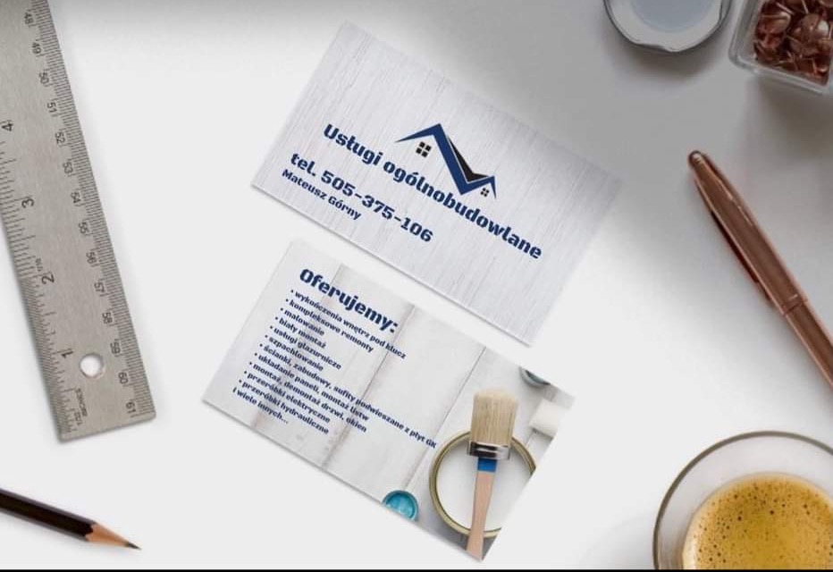 Dwie wizytówki firmy budowlanej leżące na biurku obok kawy, ołówka, linijki i spinaczy; na jednej wizytówce logo firmy z nazwą i numerem telefonu, na drugiej lista oferowanych usług budowlanych,...