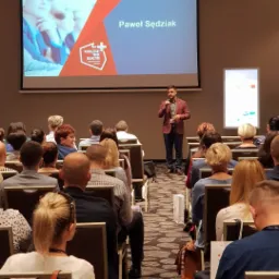 Prelegent Paweł Sędziak przemawia na konferencji o nowoczesnym marketingu handlowym dla liderów farmacji, widok zza publiczności.