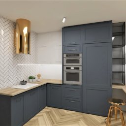 OLIV - Design projektowanie wnętrz Justyna Leszczyńska - Wnętrze kuchni z szarymi szafkami, złotym okapem i drewnianymi blatami. Na blacie butelka wina. Podłoga w jodełkę. Ściana z białych płytek.