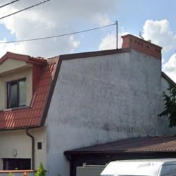 MMI- mycie malowanie impregnacja PAWEŁ LABASZ-GŁOWACKI - Dwupiętrowy dom z szarą elewacją i czerwonym dachem, widziany zza ogrodzenia i zaparkowanego białego vana. Widoczne przewody elektryczne na tle pochmurnego nieba.